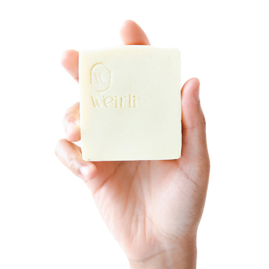 Shea and oat soap square held up by a hand