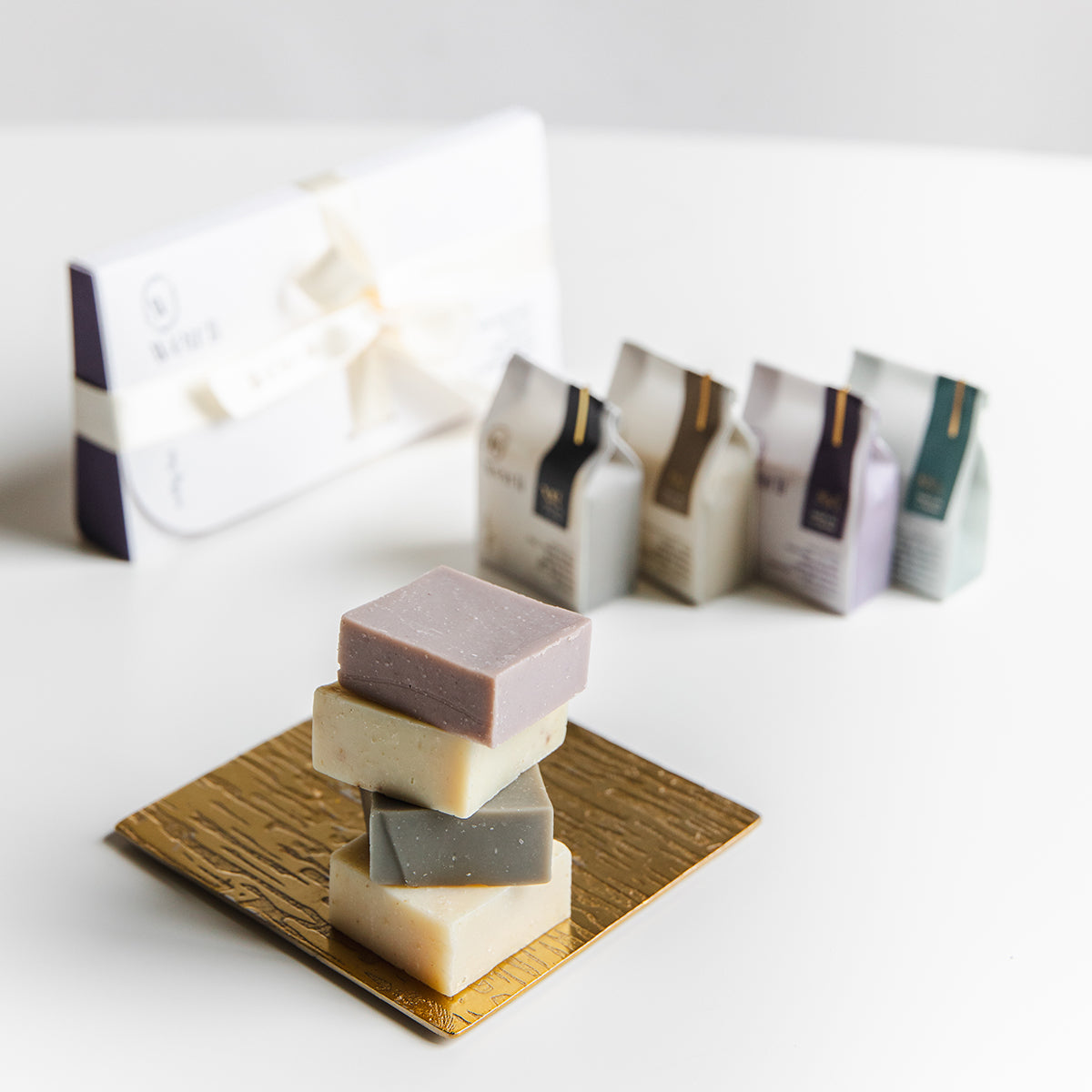 Stacked Weirli Soap Squares with packaging in the background
